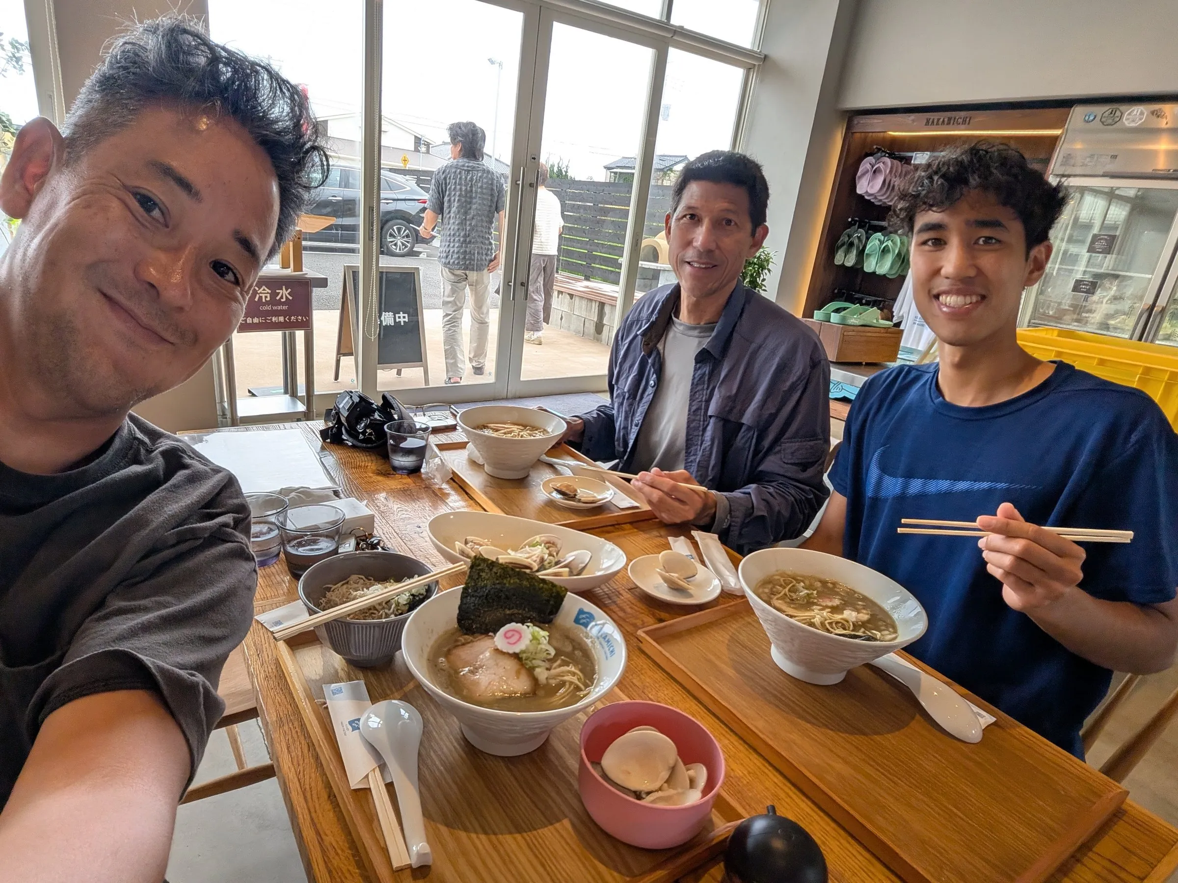 海の近くの店でラーメンを食べる広輔とゲスト2人