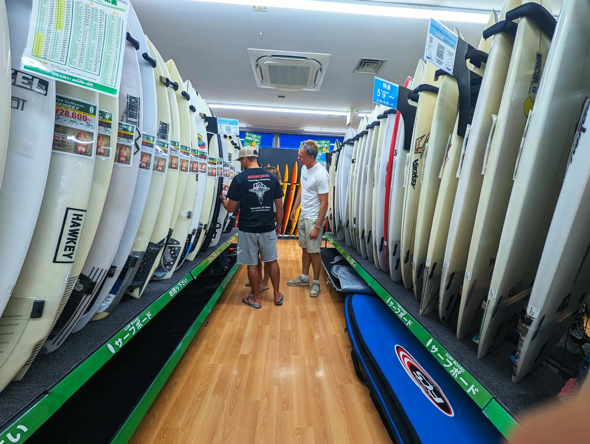 中古サーフボード店で、ずらりと並んだボードを見るゲスト